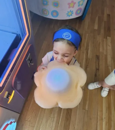 a girl holding flower shaped cotton candy